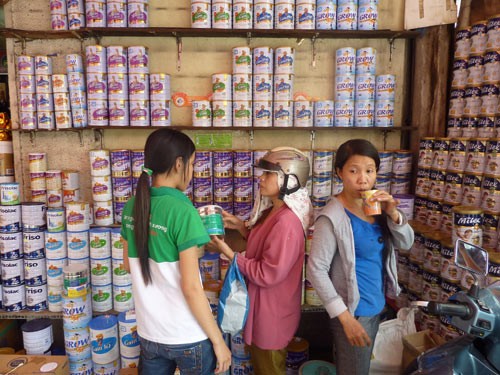 Người tiêu dùng cân nhắc khi mua sữa tại một điểm bán sữa trên đường Nguyễn Thông, quận 3- TP.HCM